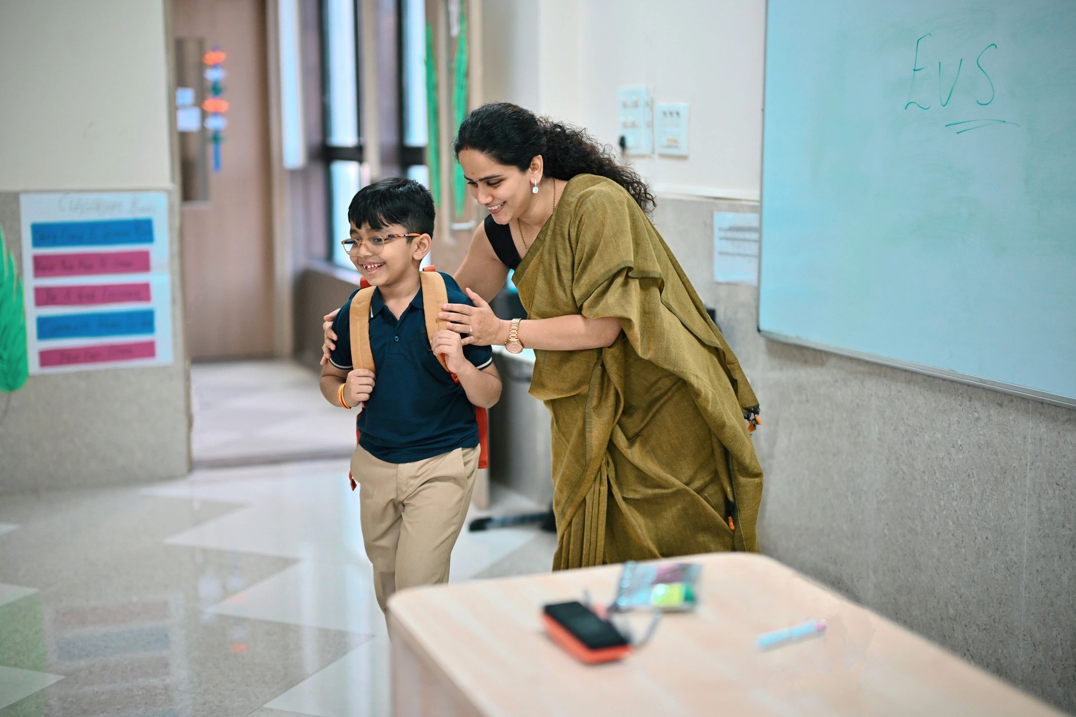 Teacher warmly supporting a young student in a classroom